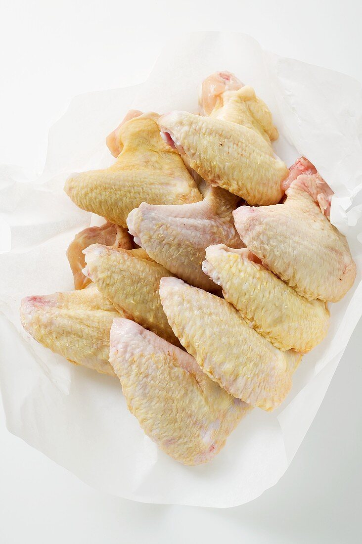 Fresh chicken wings on paper