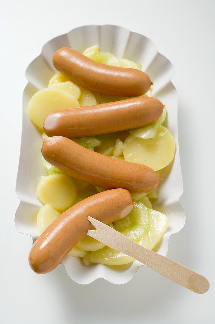 Frankfurters with potato salad in paper dish