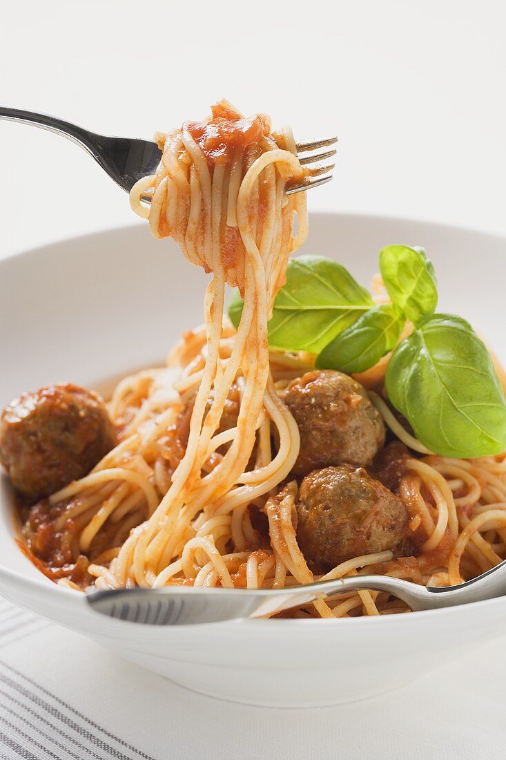 Spaghetti mit Hackbällchen, Tomatensauce und Basilikum