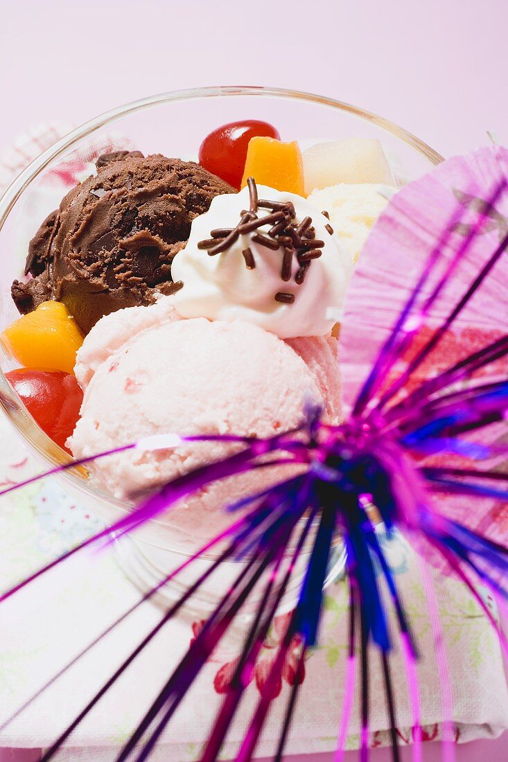 Mixed ice cream with fruit, cream and cocktail umbrella