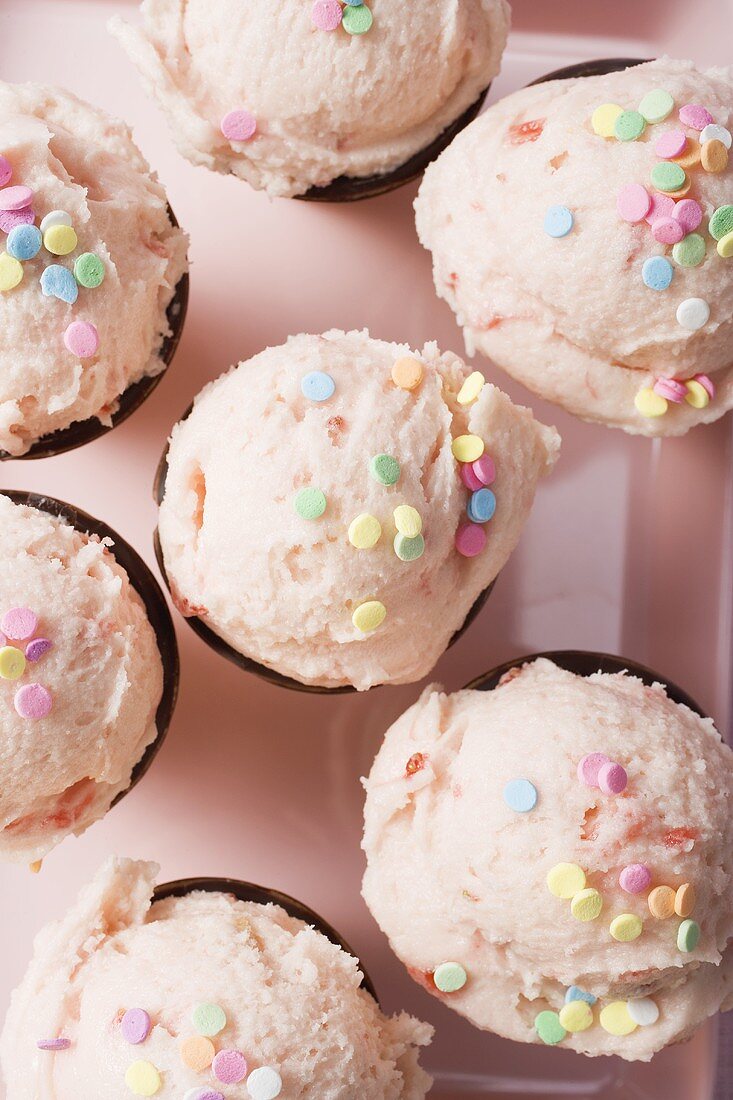 Strawberry ice cream cones on pink tray (overhead view)