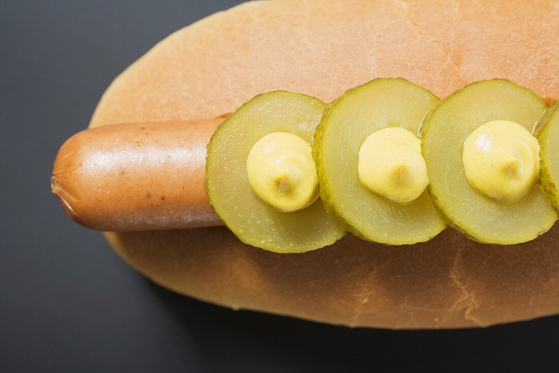 Hot Dog mit Essiggurken und Senf (Draufsicht)