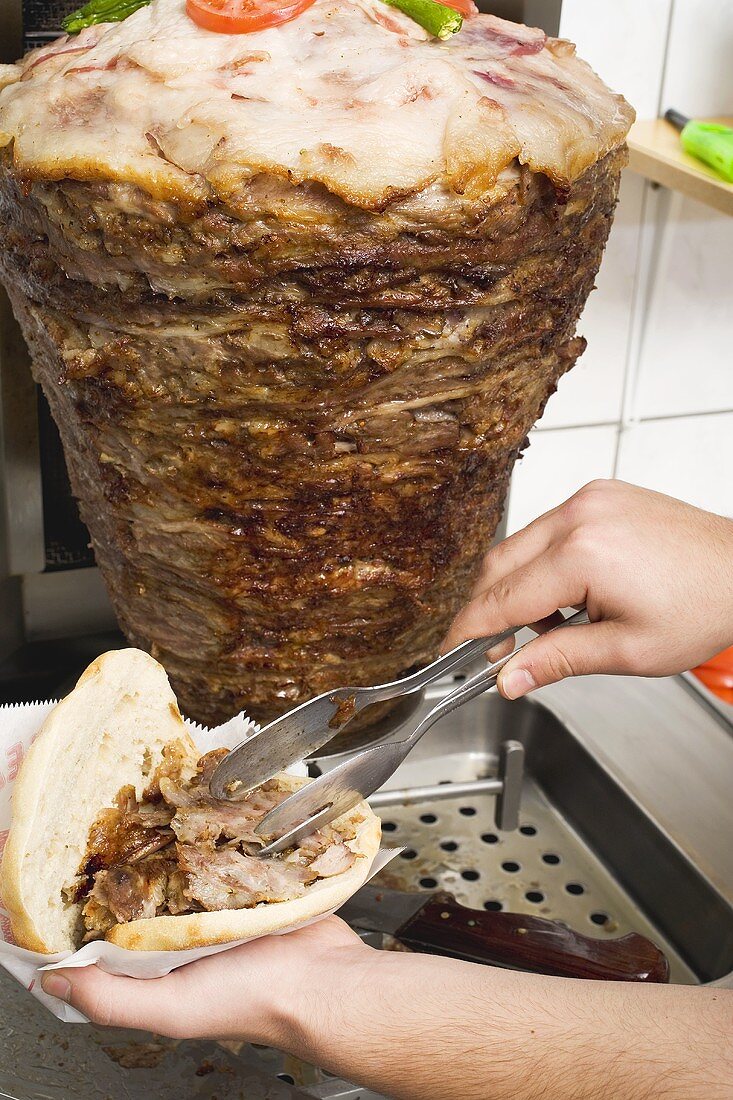 Making a döner kebab: filling pita bread with meat