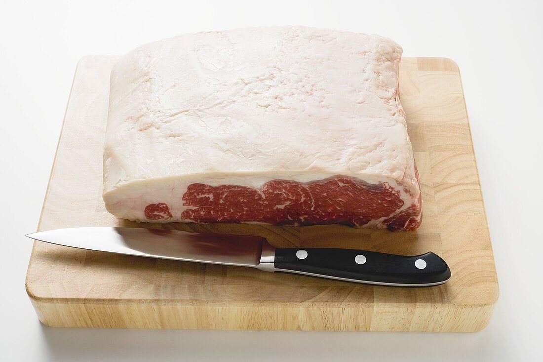 Sirloin steak on chopping board with knife