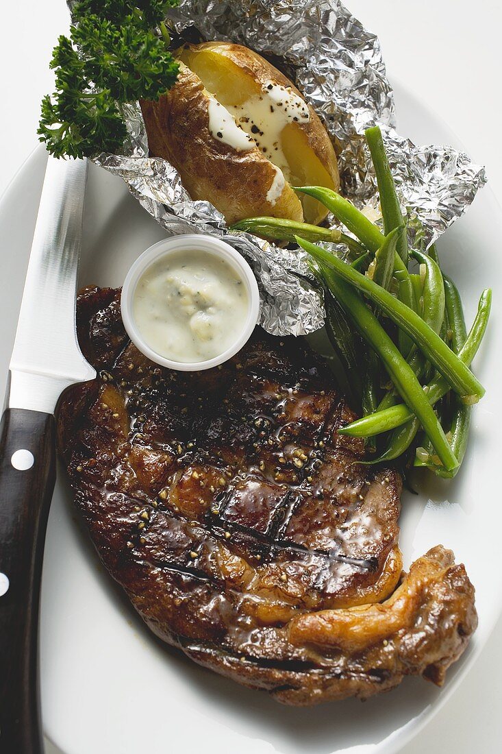 Gegrilltes Rindersteak mit Folienkartoffel, Bohnen und Dip