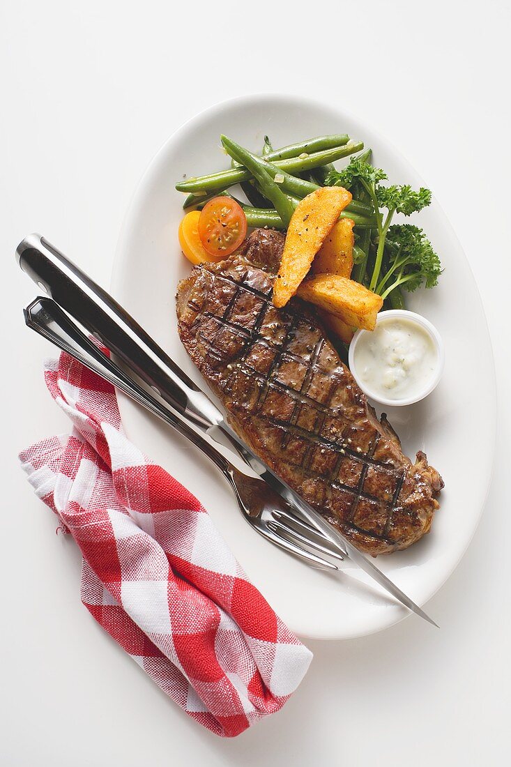 Grilled beef steak with vegetables and dip