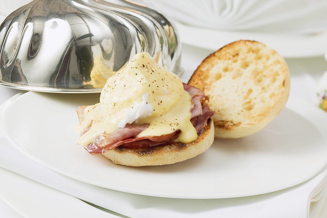 Eggs Benedict on plate with dome cover