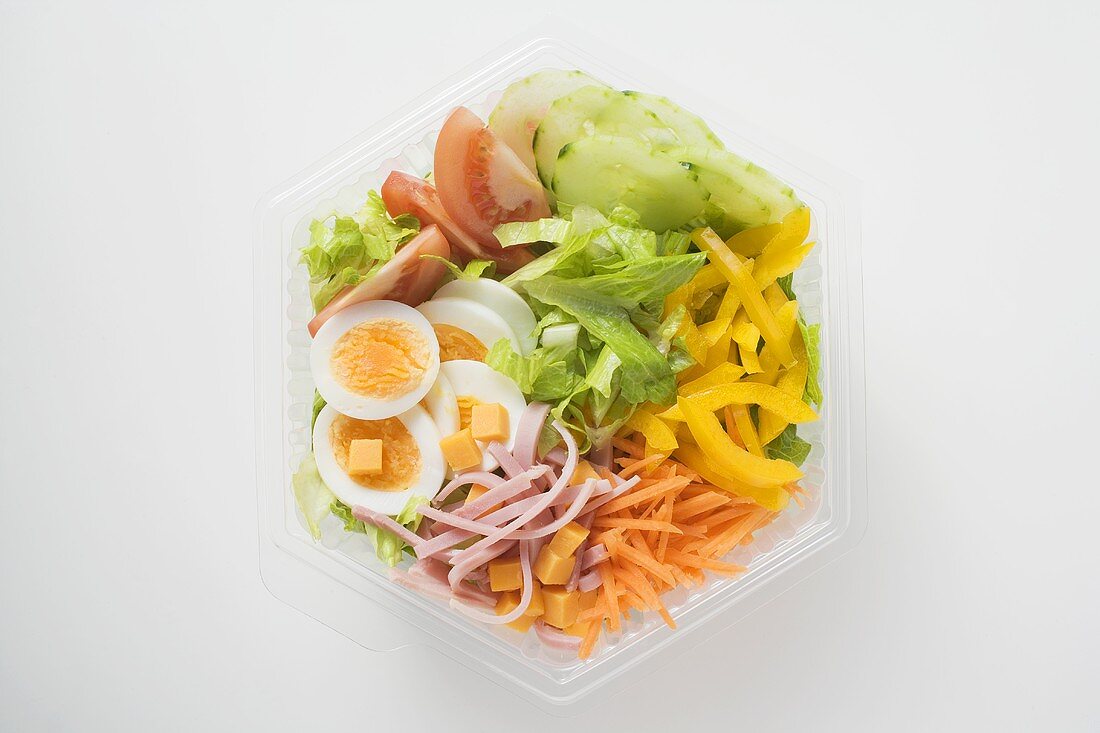 Eissalat mit Schinken, Käse, Ei und Gemüse in Plastikschale
