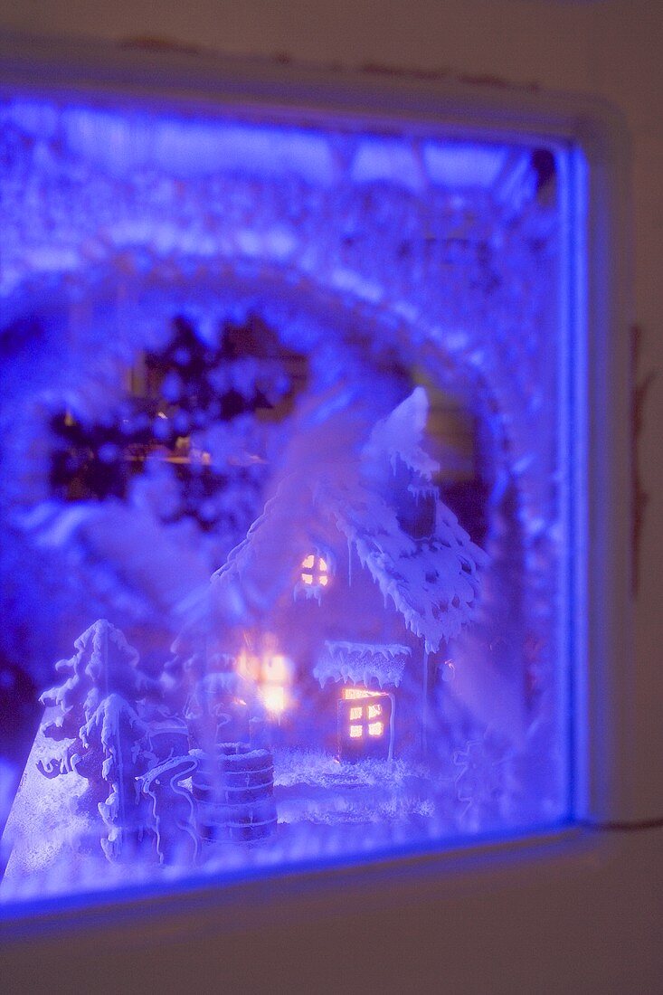 View of a gingerbread house through a blue window