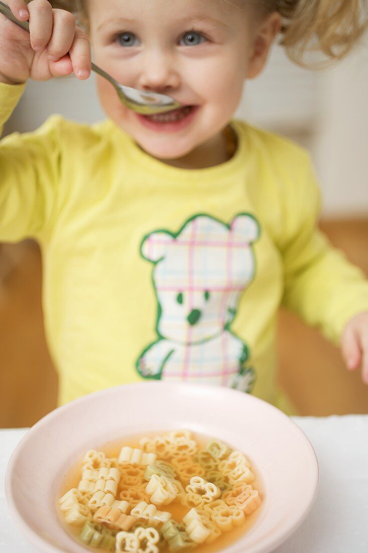 Kleines Mädchen isst Nudelsuppe