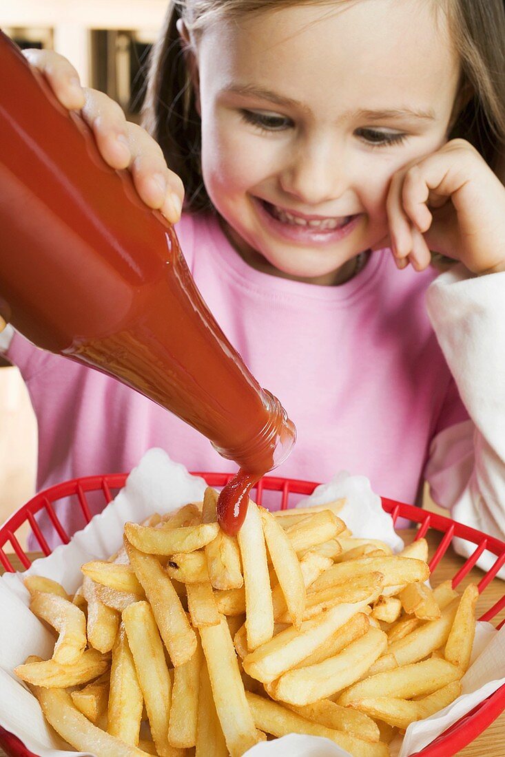 Girl putting ketchup on chips