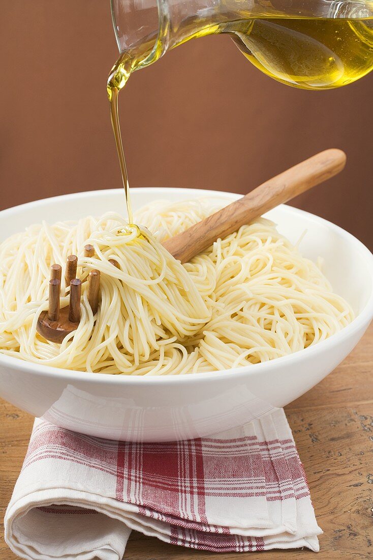 Gekochte Spaghetti mit Olivenöl begiessen