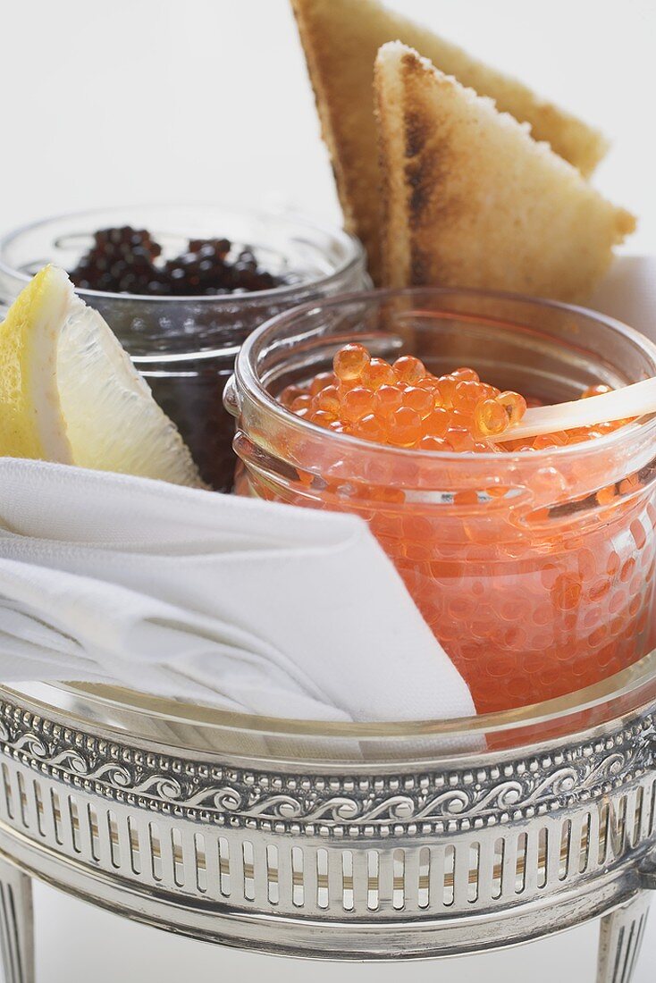 Black caviar and Keta caviar in jars, toast