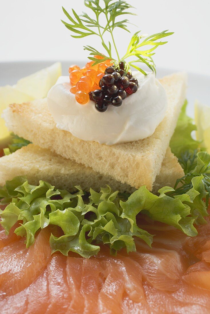 Soft cheese & two sorts of caviar on toast on smoked salmon