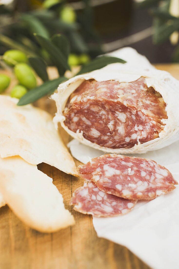Salami and crackers on wooden table