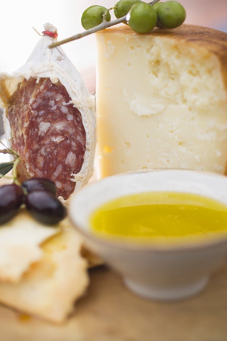 Olives, crackers, olive oil, Parmesan and salami