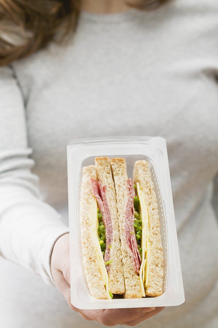 Frau hält verpackte Sandwiches