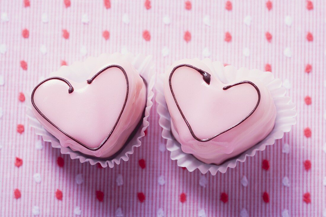 Two pink heart-shaped petit fours (overhead view)