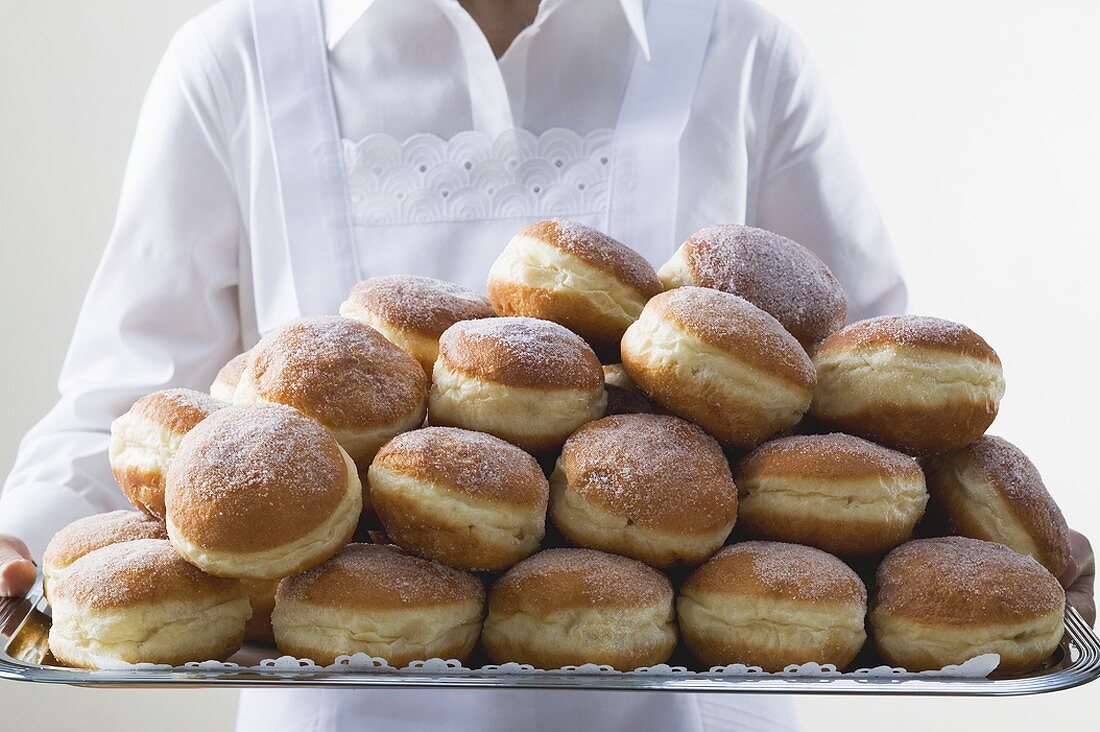 Waitress holding tray piled high with doughnuts
