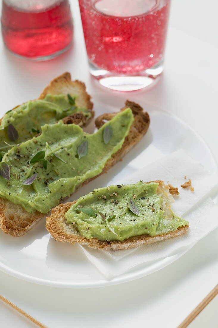 Bruschetta mit Avocadocreme auf Teller, Campari Soda