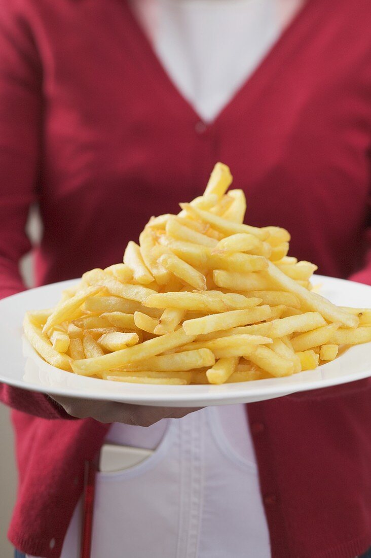 Kellnerin serviert Teller mit einem Haufen Pommes frites