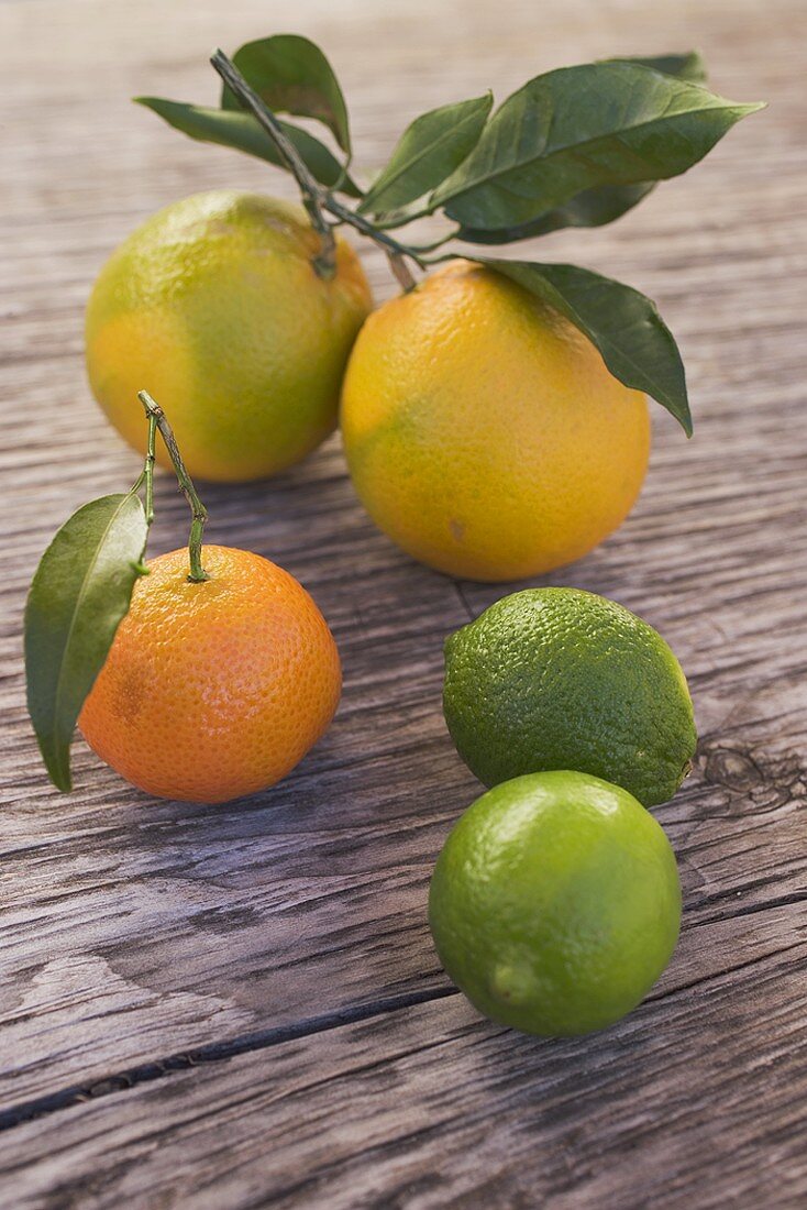 Oranges, clementine and limes on wooden background