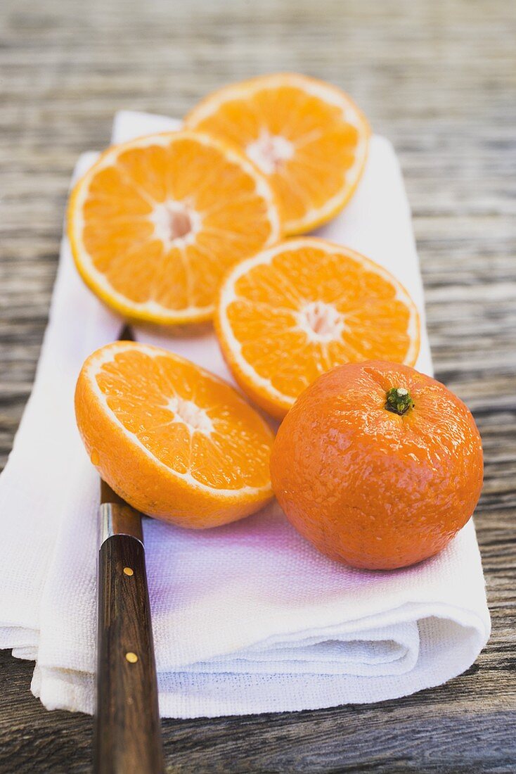 Clementines, whole and halved, on white cloth