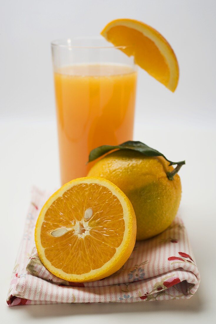 Glass of orange juice and oranges