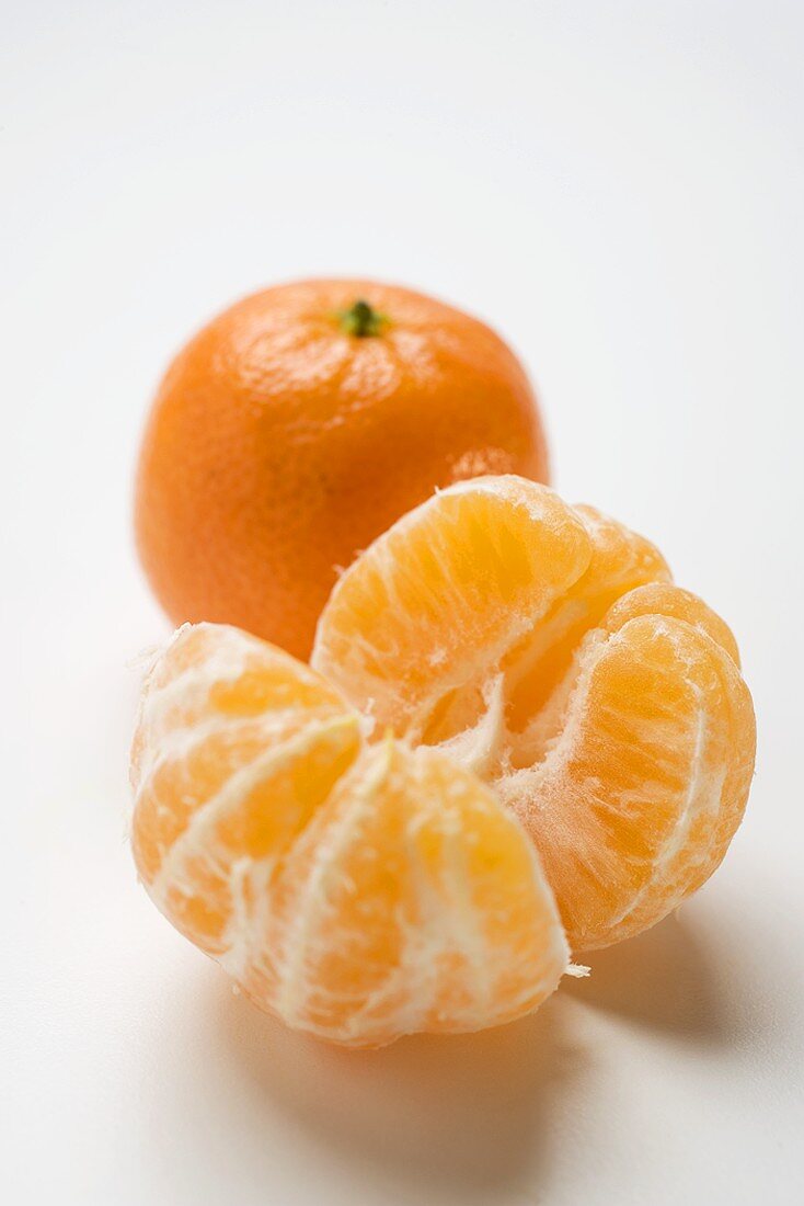 Two clementines (peeled and unpeeled)
