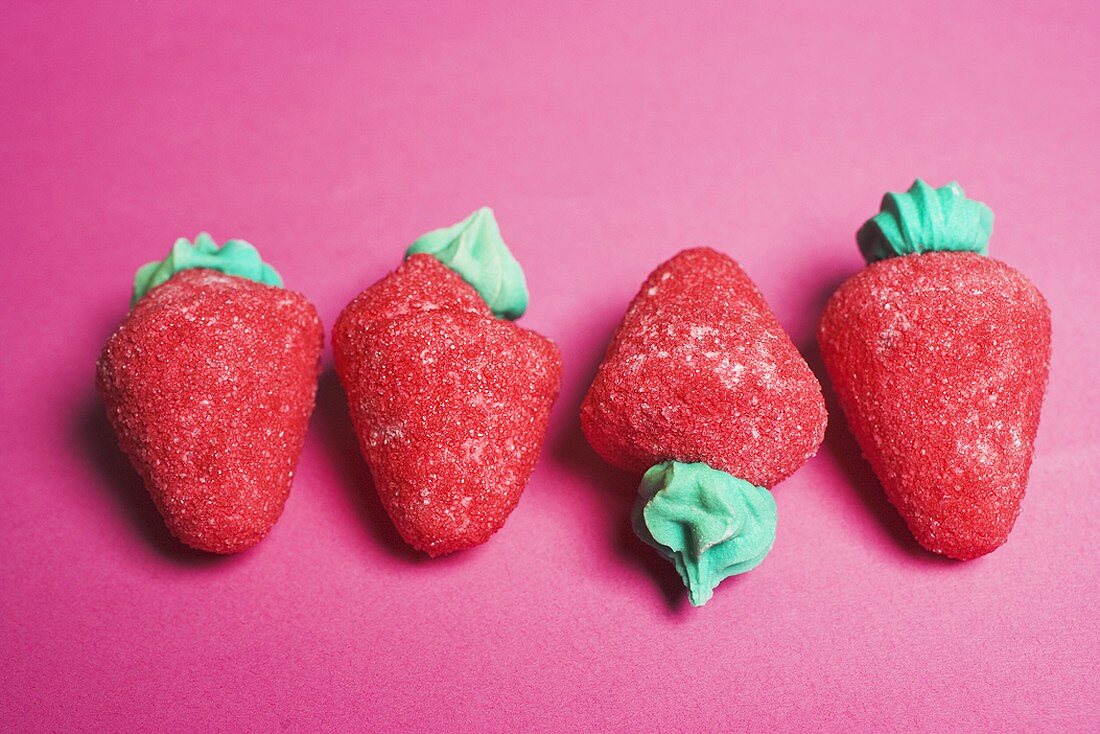Sugar strawberries on red background