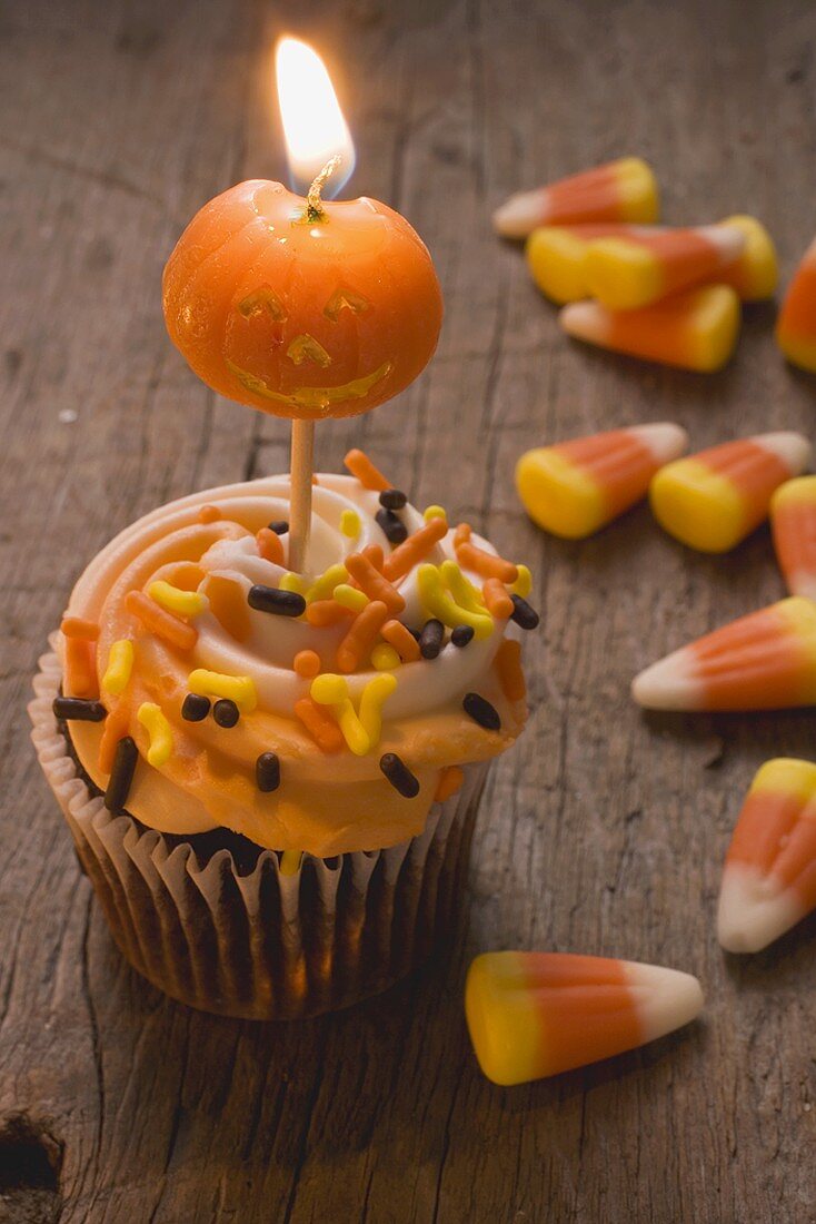 Cupcake mit Kürbiskerze und Candy Corn zu Halloween (USA)