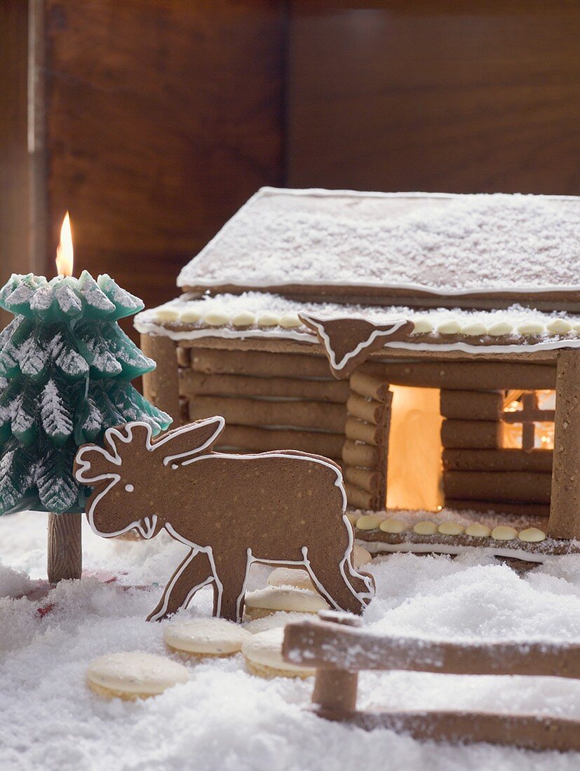 Gingerbread log cabin in snowy forest with gingerbread elk