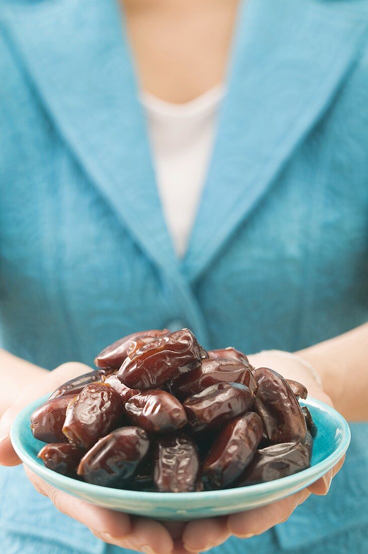 Woman holding dish of dates