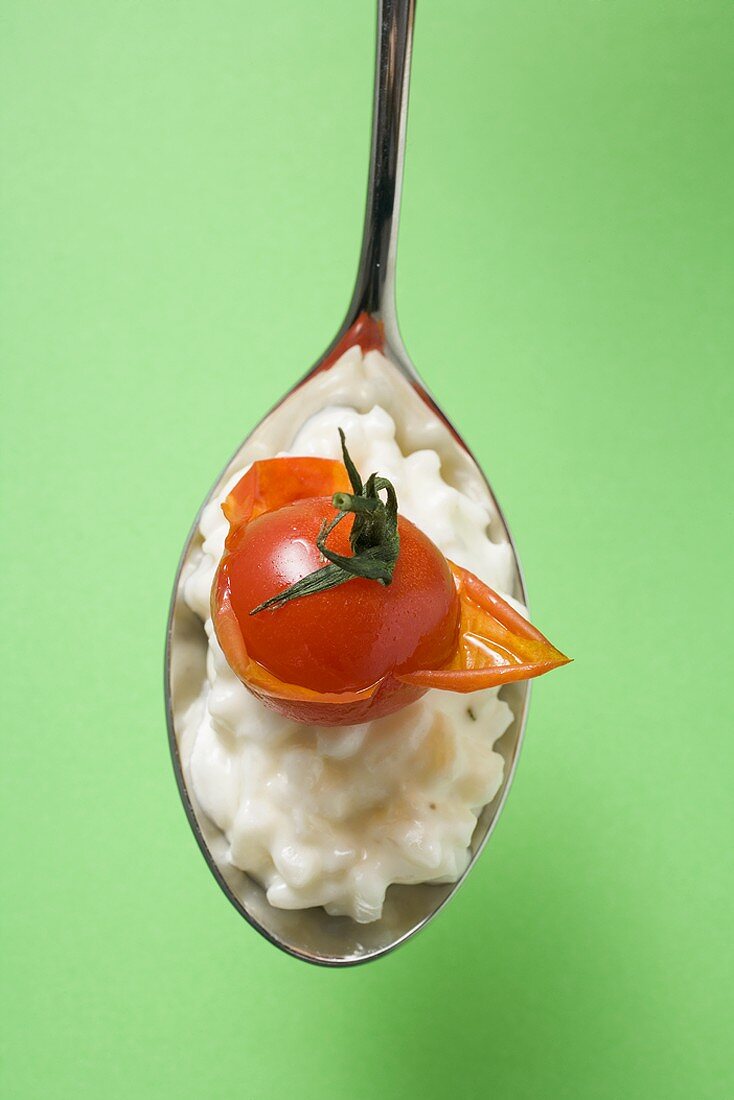 A spoonful of risotto with cherry tomato (overhead view)