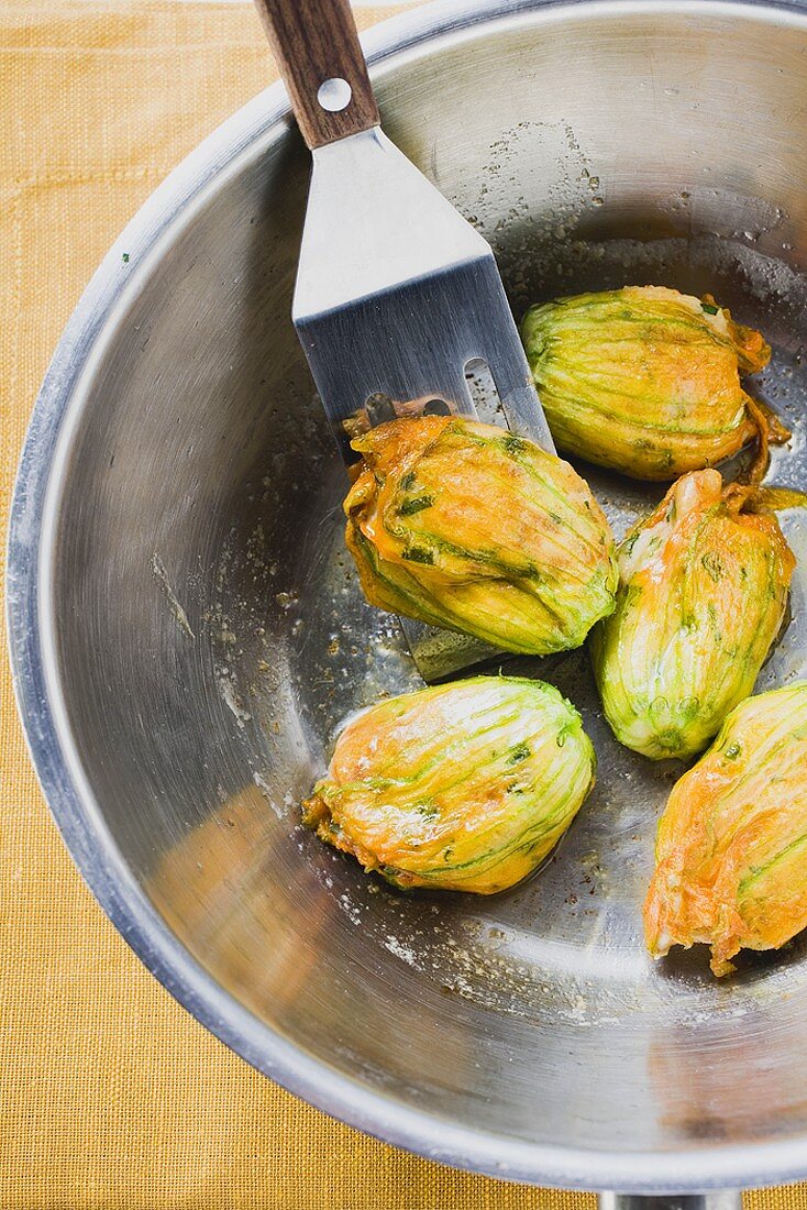 Fried courgette flowers in pan (overhead view)
