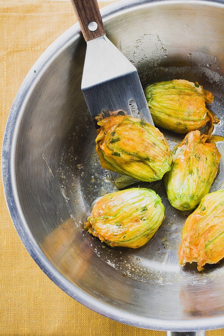 Frittierte Zucchiniblüten in Schüssel (Draufsicht)