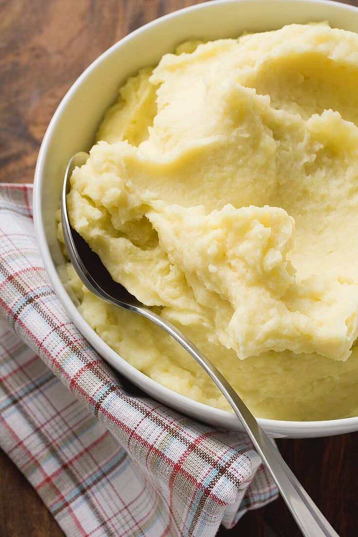 Mashed potato in white bowl with spoon