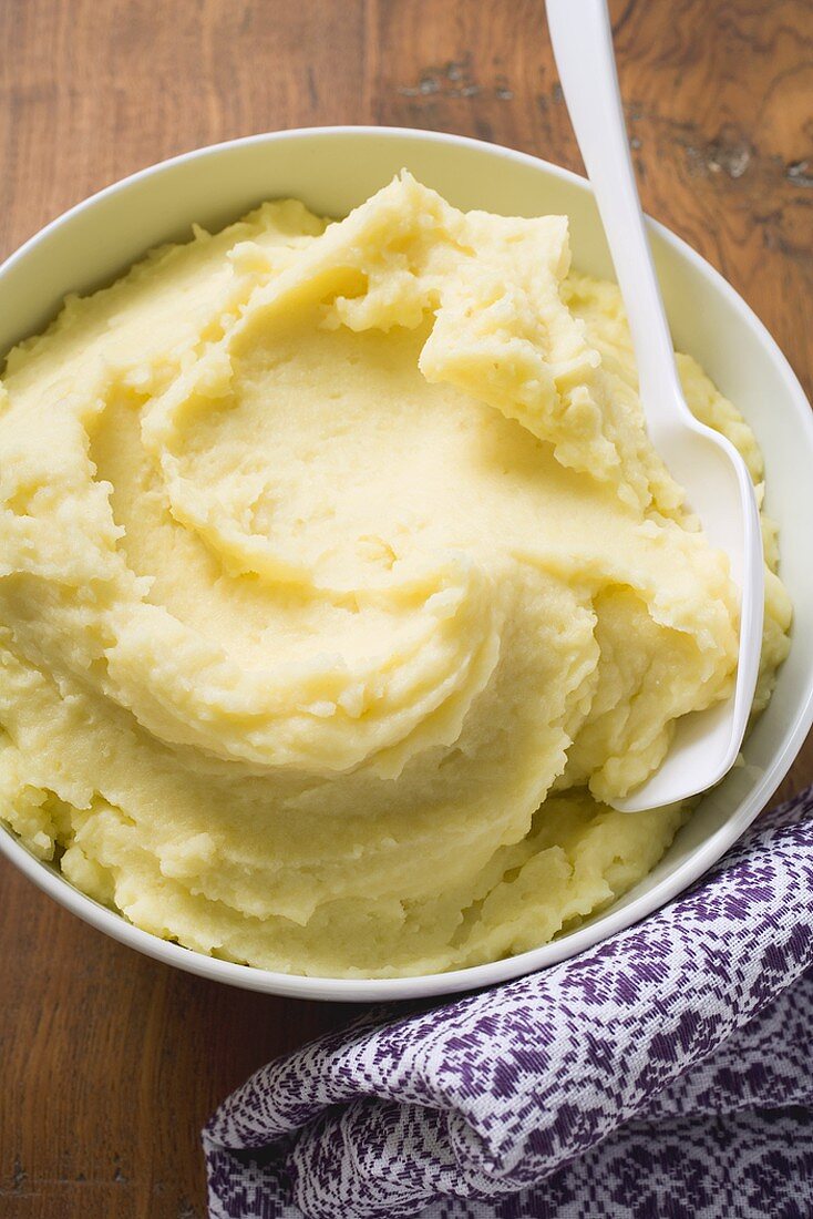Mashed potato in white bowl with spoon