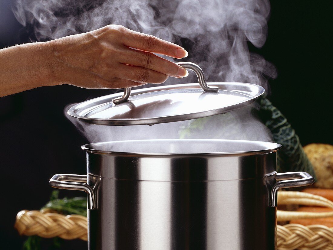Hand Lifting Lid of Steaming Stock Pot