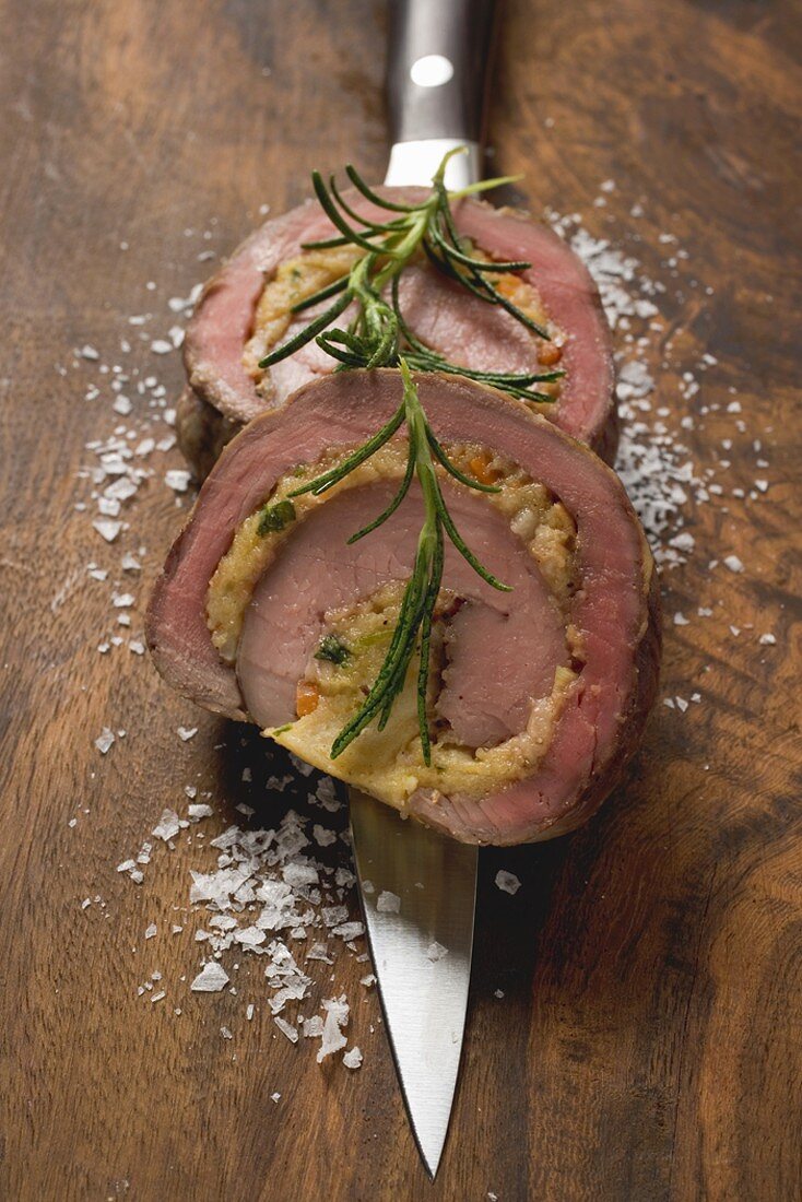 Two slices of stuffed beef roulade with rosemary