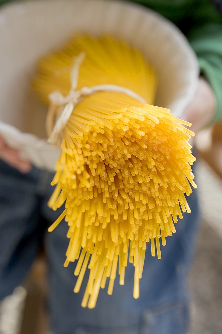 Person hält Schüssel mit Bund Spaghetti