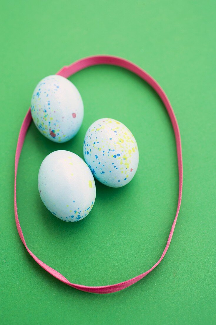 Speckled Easter eggs surrounded by pink ribbon