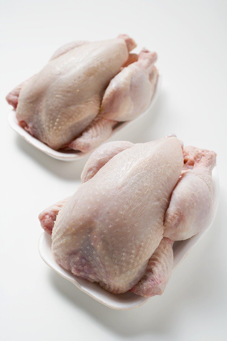 Two fresh chickens on polystyrene trays