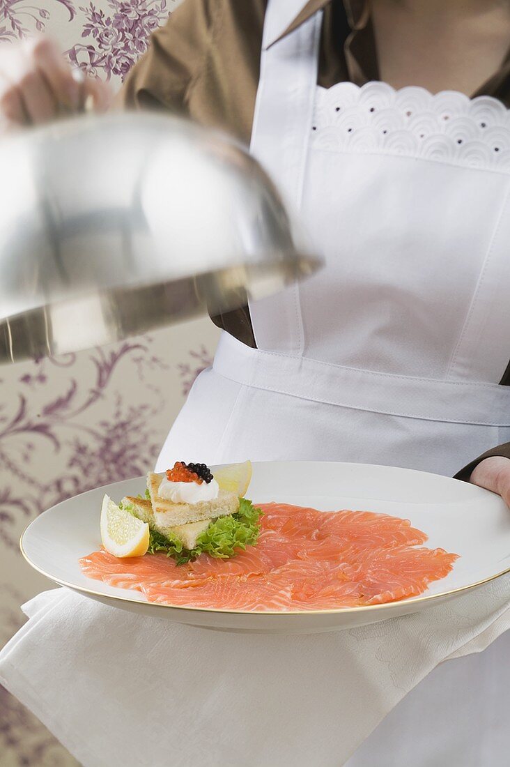 Chambermaid serving smoked salmon with toast