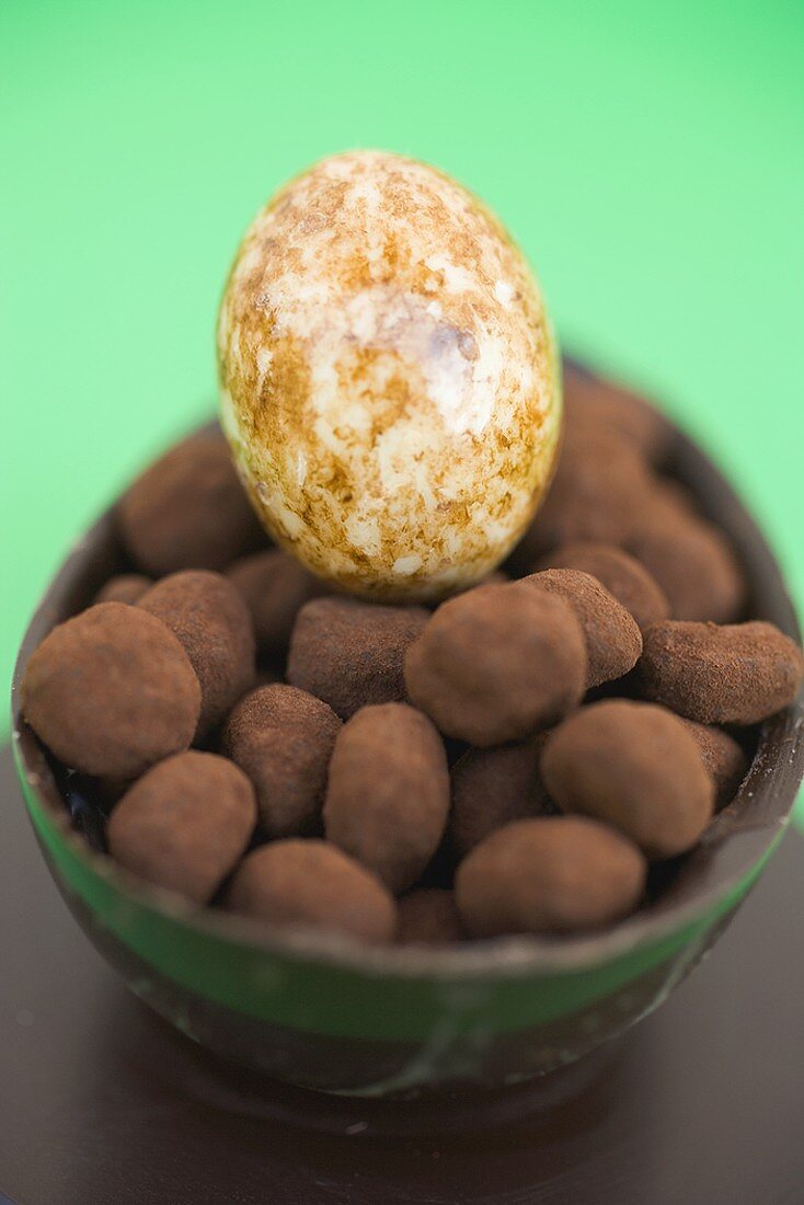 Half a chocolate egg filled with small truffles