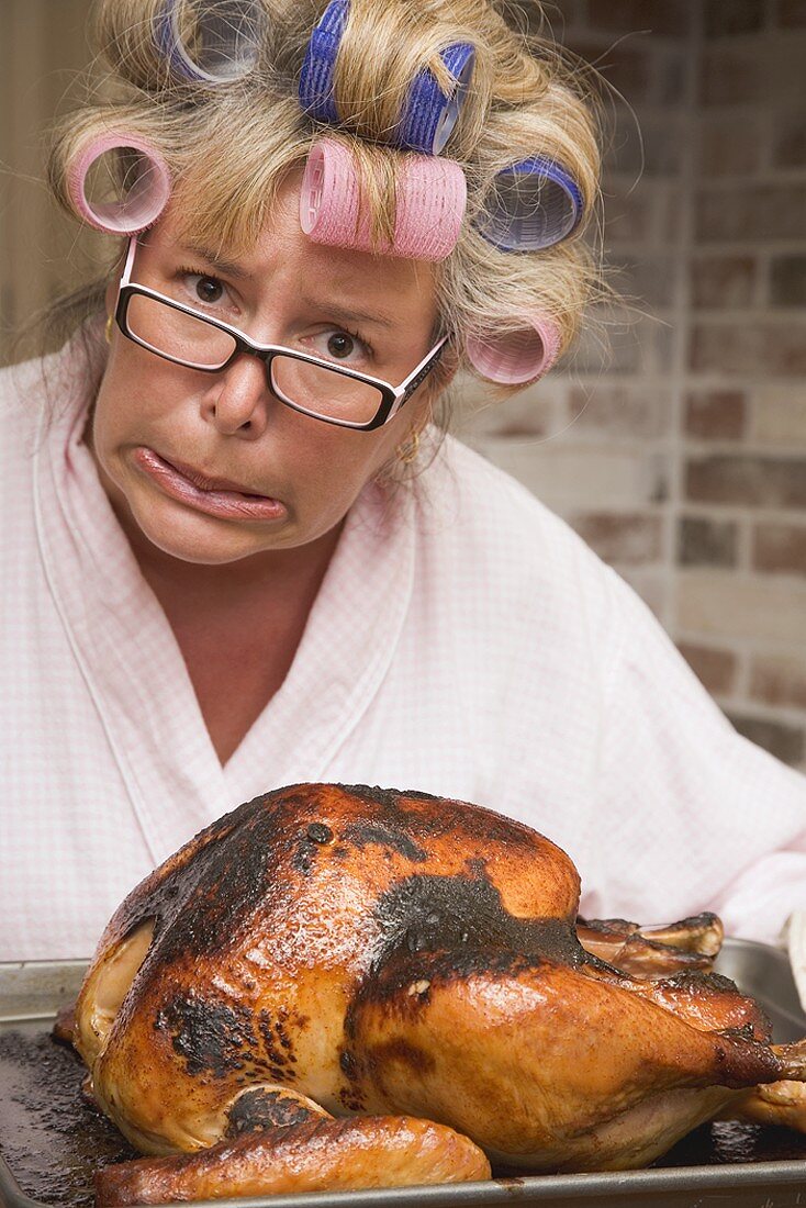 Horrified housewife with burnt turkey