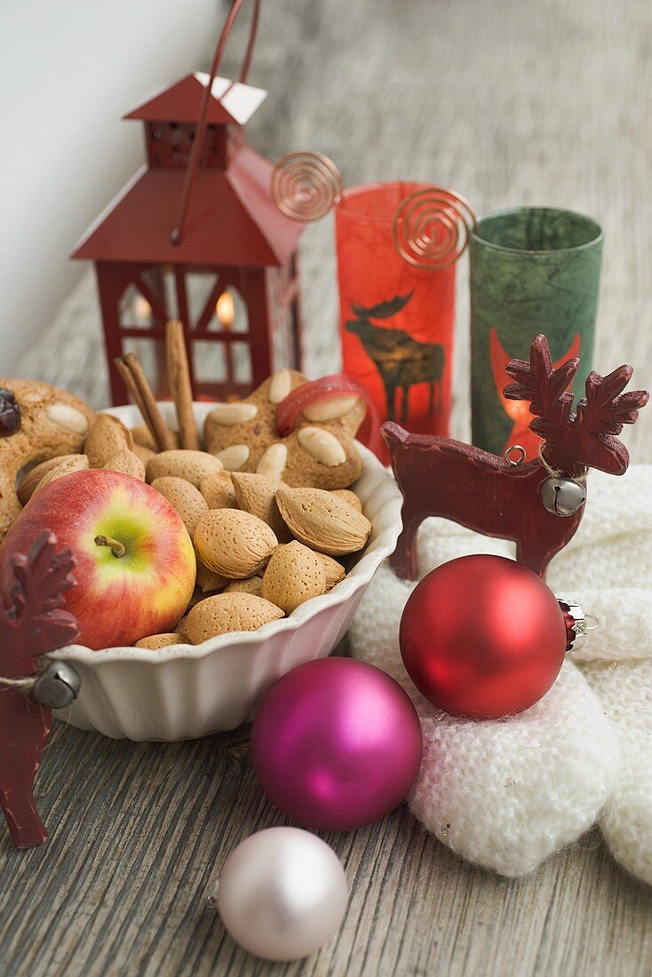 Weihnachtsdeko mit Apfel, Nüssen, Laterne, Handschuhen