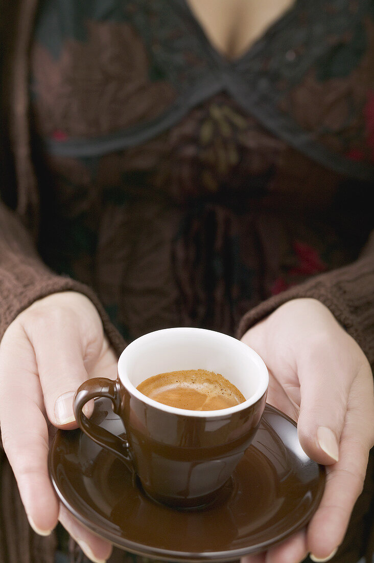 Frau hält Tasse Espresso