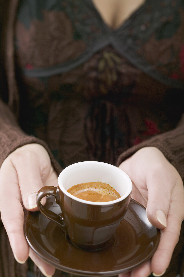 Woman holding cup of espresso