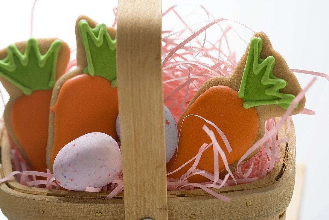 Easter biscuits (carrots) and sugar eggs in basket